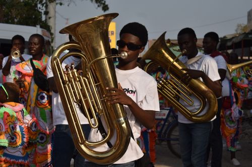 Free Energetic street band performing with brass instruments during a daytime celebration. Stock Photo