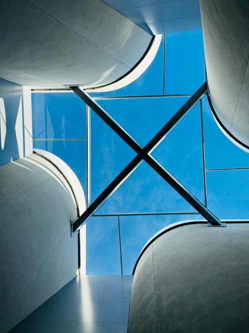 Free View of a modern architectural glass skylight against a blue sky. Stock Photo