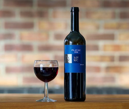 Free Wineglass and a Bottle of Plavac Tomic Red Wine Stock Photo