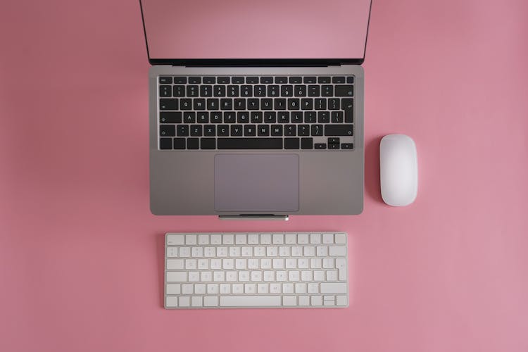 Ith Mouse And Keyboard. Top View Pink Colored Table. Empty Clean Background.