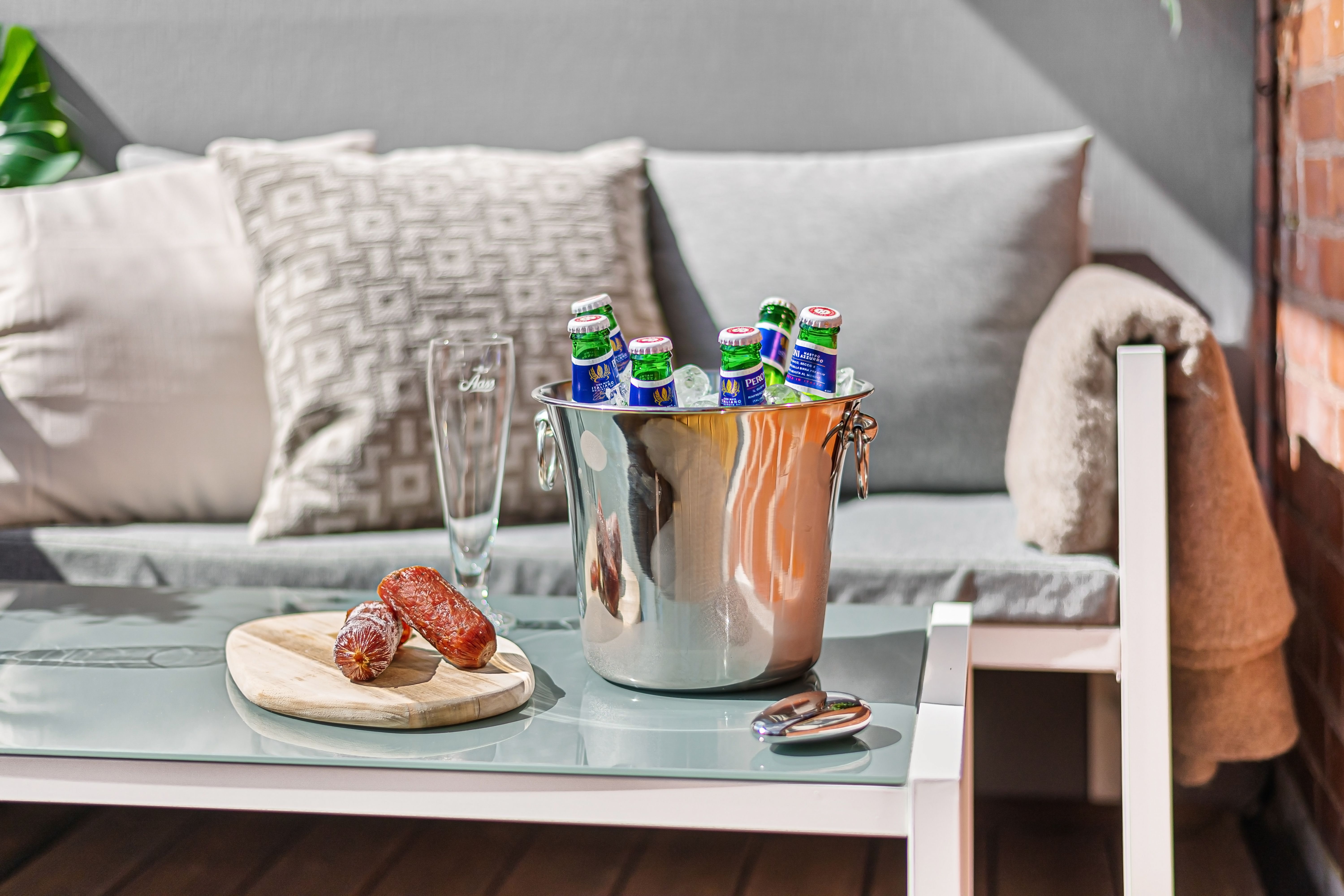 A cozy living room scene with an ice bucket filled with beer bottles, sausages, and stylish decor.