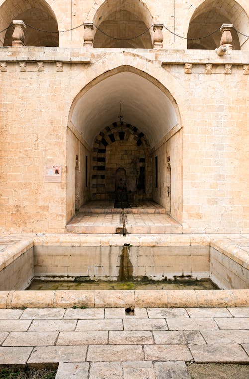 A fountain in an old building with arches