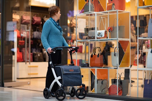 Senior woman with rollator walker shopping for luxury handbags at a mall.