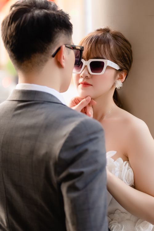 Free A stylish couple in sunglasses shares a tender moment, showcasing elegance and love. Stock Photo