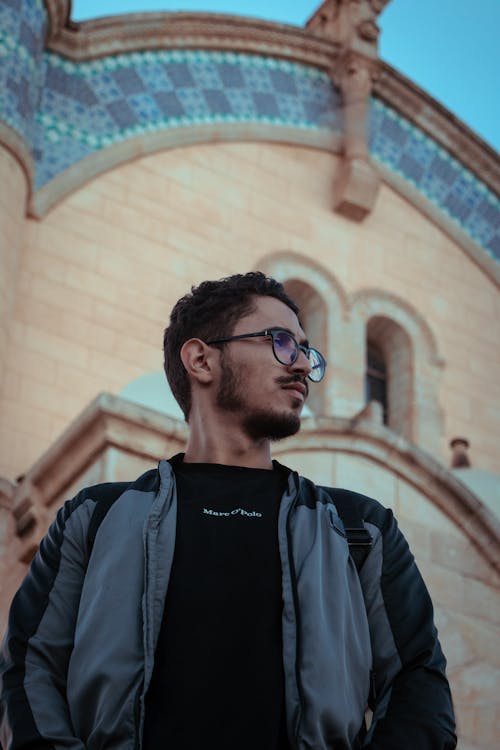 A man in glasses standing in front of a church