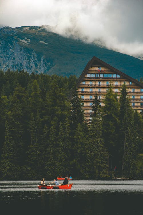 People Rowing a Boat on a Lake in the Mountains 