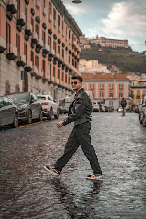 Young Man in a Leather Jacket Walking in a City 