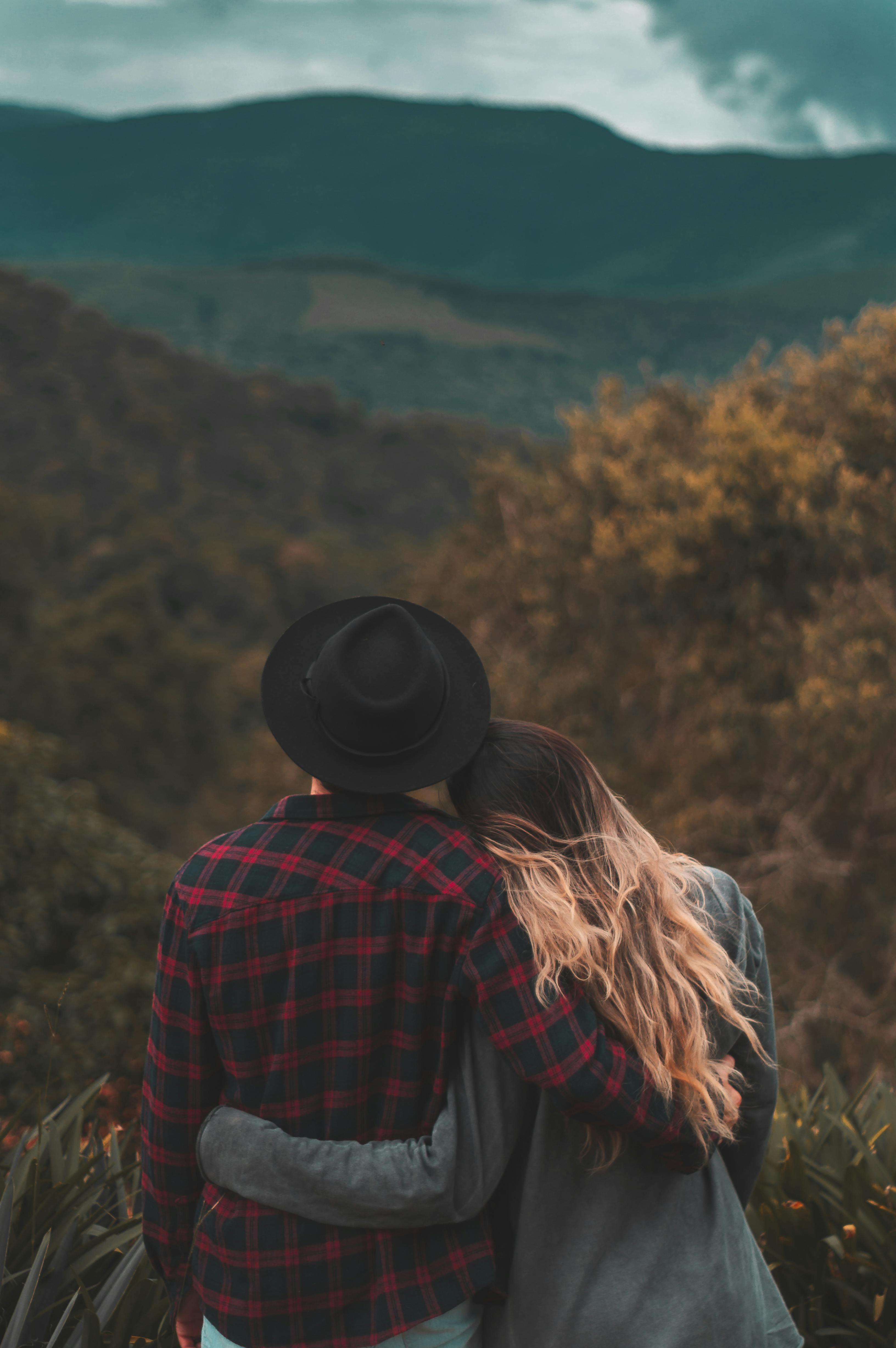 Couple standing on top of hill | Photo: Pexels