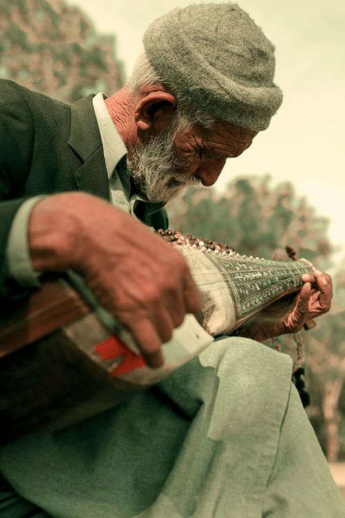 Free Elderly man outdoors playing a traditional instrument in Islamabad, Pakistan, showcasing cultural heritage. Stock Photo
