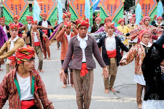 Traditional dancers in colorful attire performing at a festival parade in Davao City, Philippines.