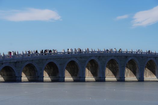 People Walking on the Arch Bridge at the Summer Palace in Beijing, China 