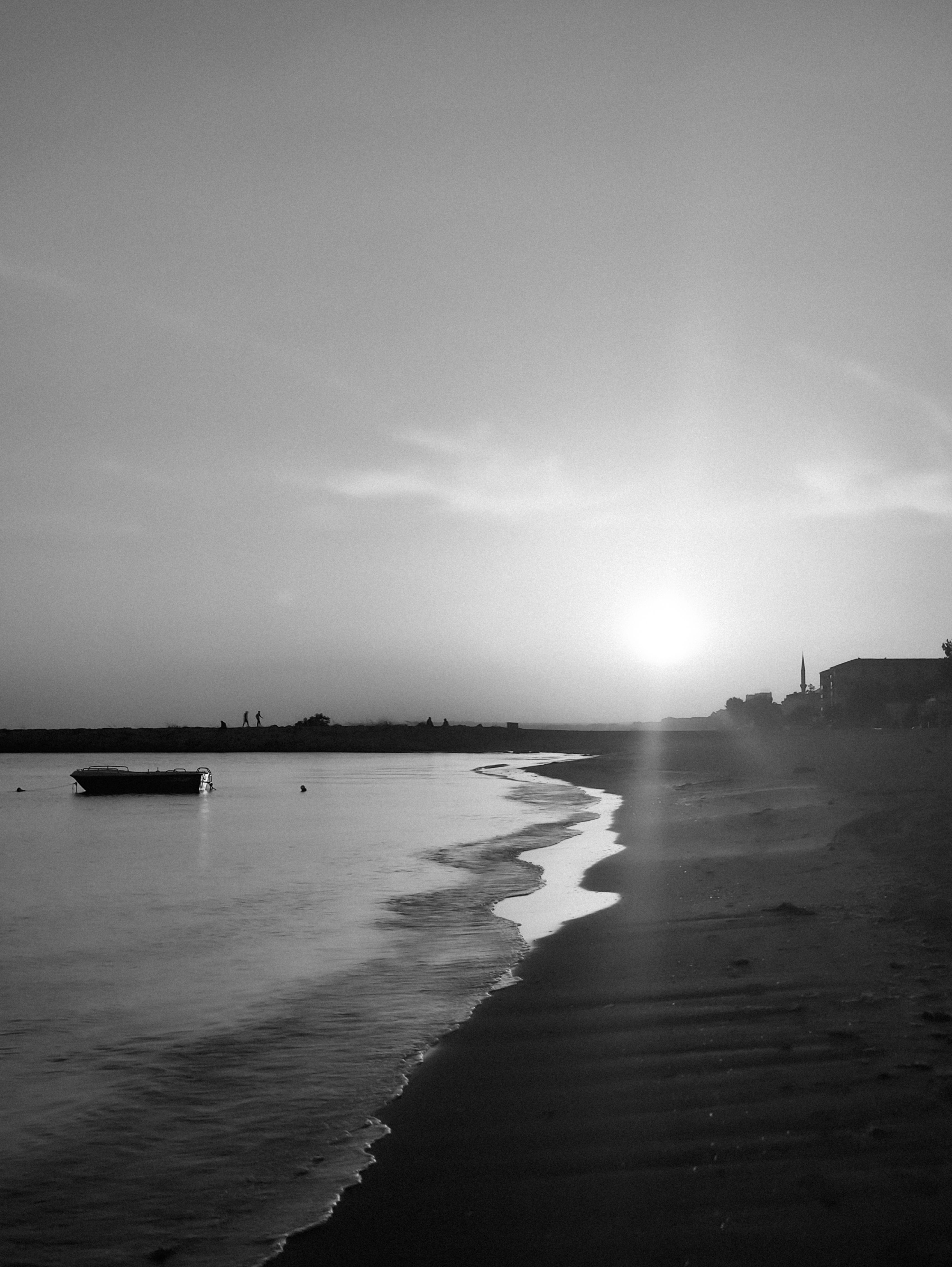 A black and white photo of a boat on the beach · Free Stock Photo