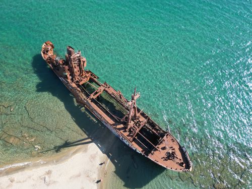 Free Aerial view of the rusting shipwreck on Selinitsa Beach, Gytheio, with clear turquoise waters. Stock Photo