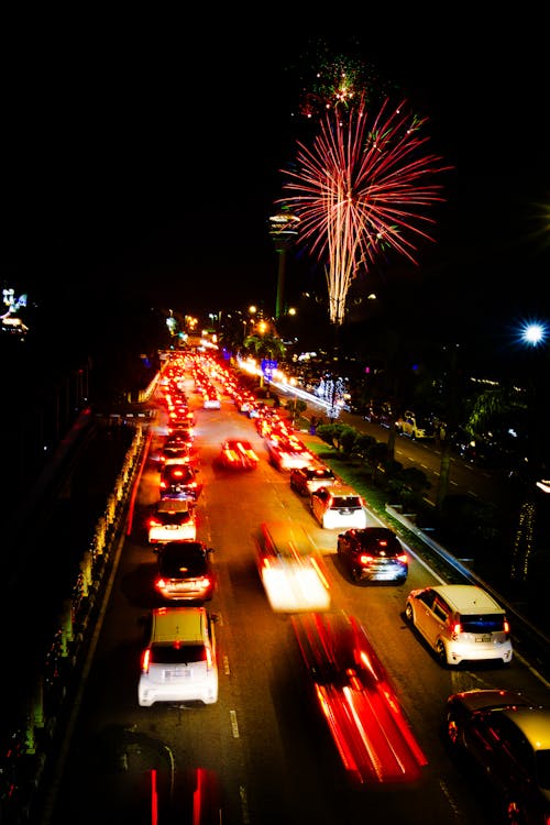 View of Cars on a Road and Fireworks against Dark Sky 