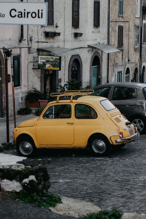 A Vintage Yellow Fiat 500 Parked on a Street in City · Free Stock Photo