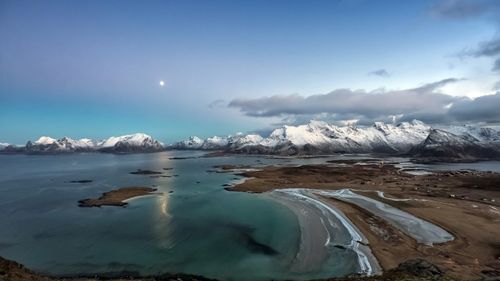 Free Stunning aerial view of Fredvang's coastline against snowy mountains under a clear sky. Stock Photo