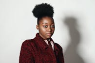 一位年轻女子留着非洲发型，穿着时尚的红色外套，肖像优雅