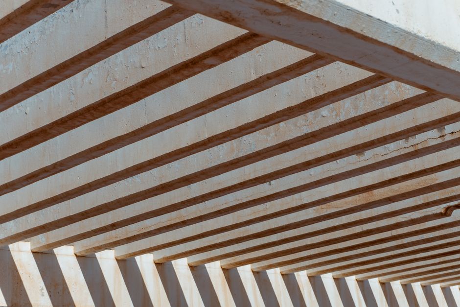 Close-up view capturing the geometric pattern of a concrete architecture with sunlight casting shadows, creating a modern abstract aesthetic.