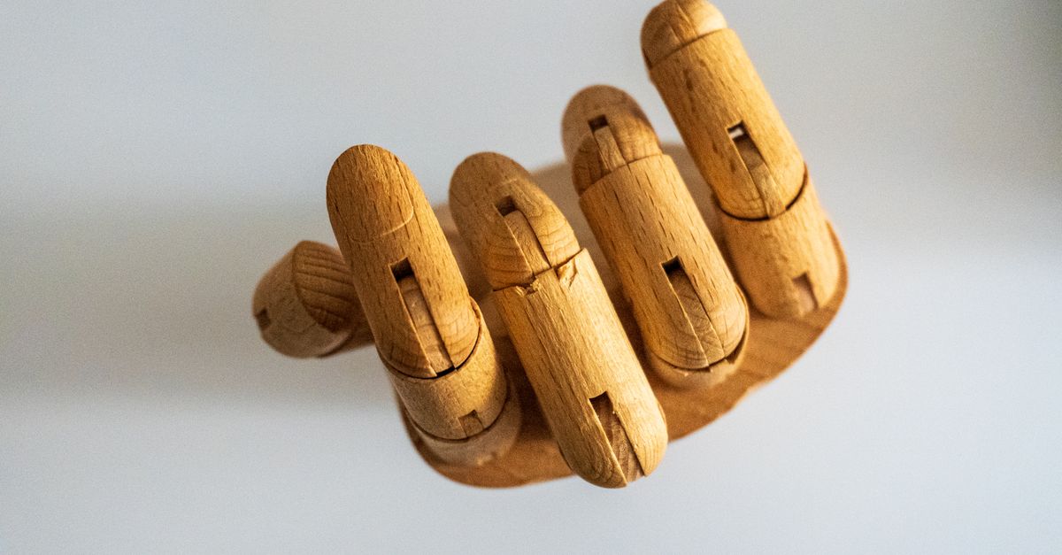 Detailed wooden hand model for art and design on a white background.