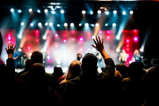A lively concert scene with an enthusiastic crowd enjoying a vibrant stage performance.