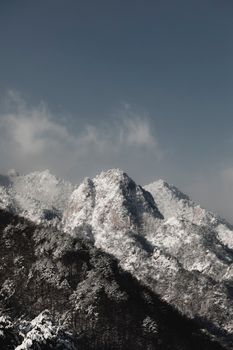 Scenic view of snow-covered mountains against a clear blue sky during winter.