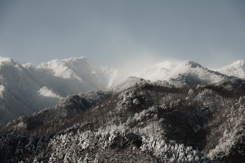 A view of snow covered mountains with a blue sky