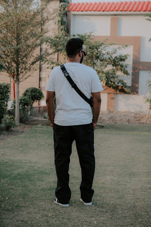 Back View of Man in T-shirt Standing in Garden