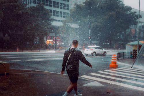 Back View of Man Walking in Rain