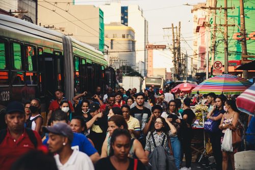 Free Busy urban street market featuring diverse crowd and public transportation. Stock Photo