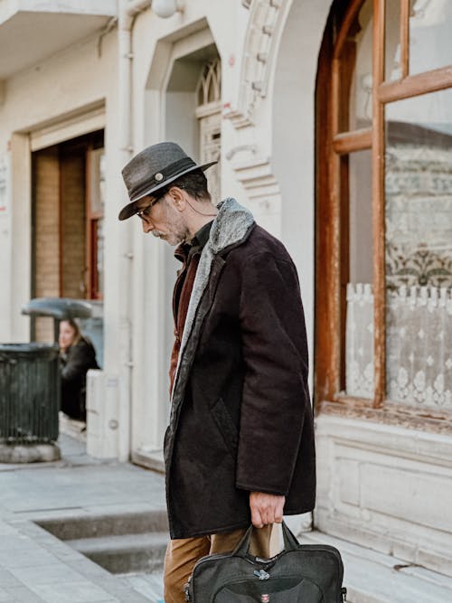 Elegant Man Standing on a Sidewalk in City 