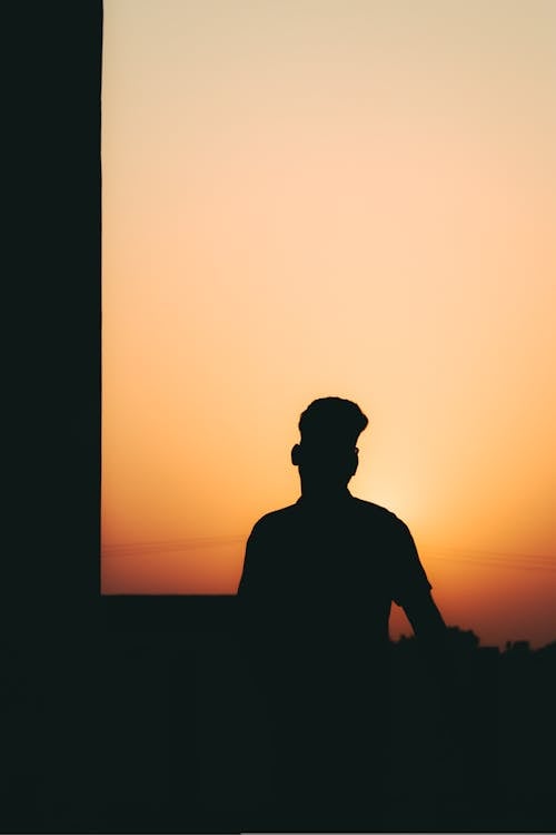 Silhouette of a Man Standing on a Terrace at Sunset