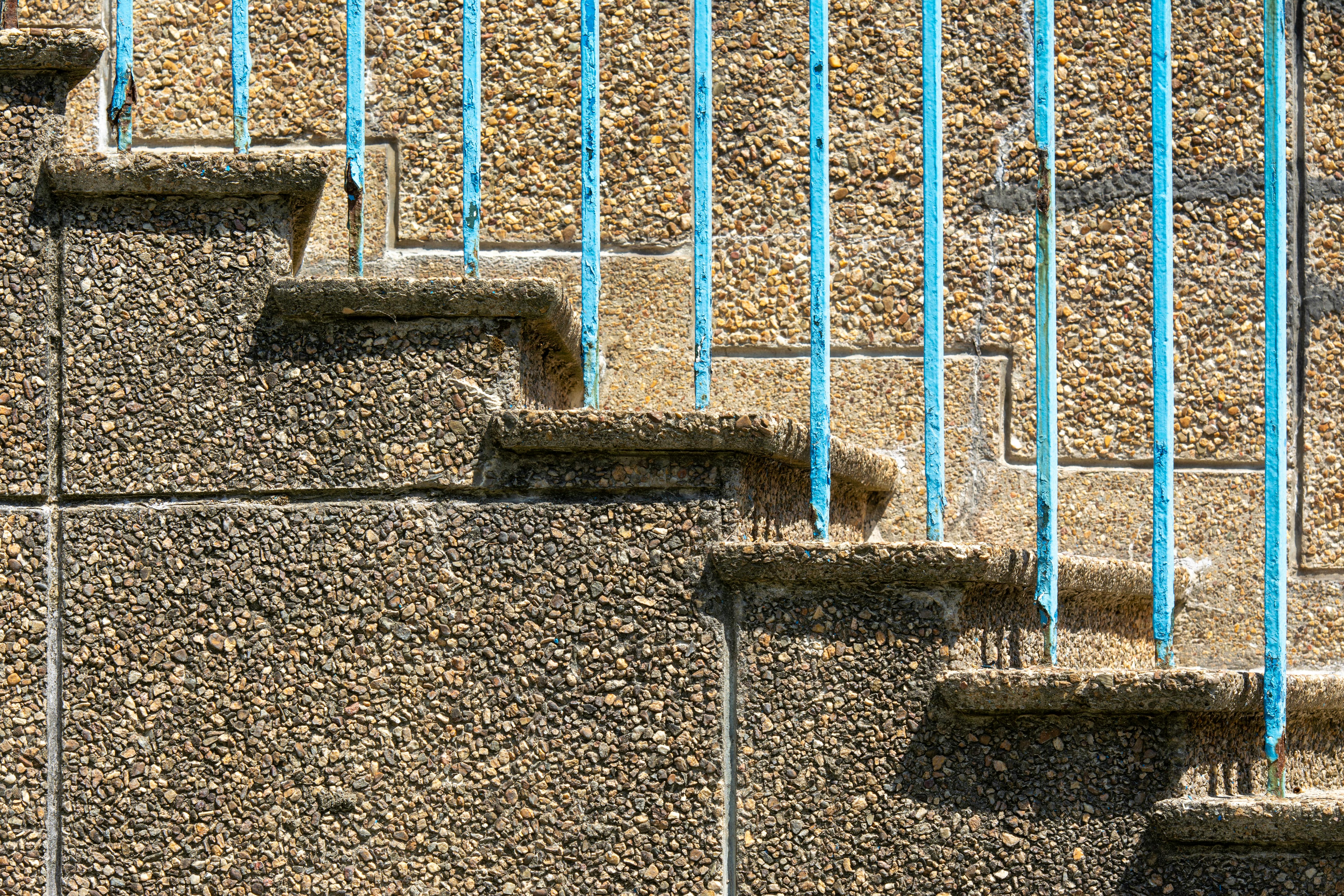 A blue railing on a cement wall · Free Stock Photo