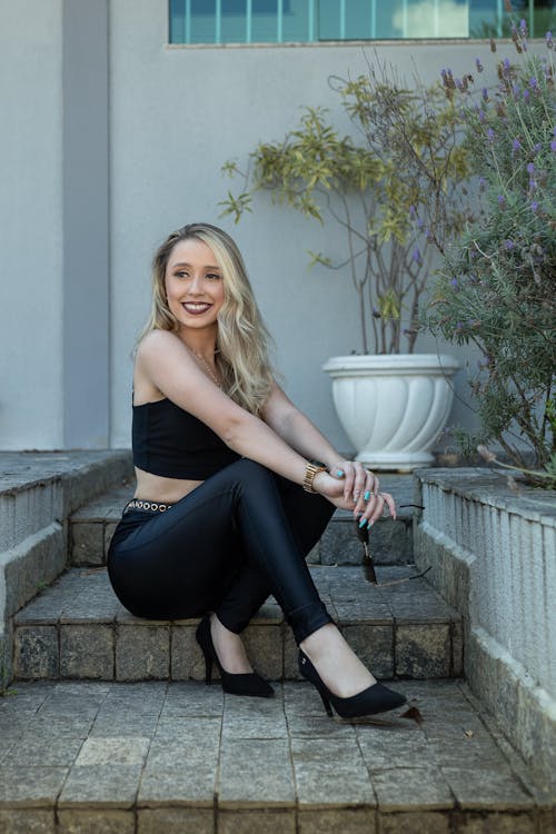 Smiling Blonde Woman Sitting on Stairs