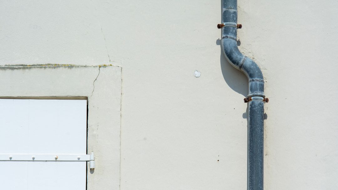 A metal pipe running down the exterior wall of a building