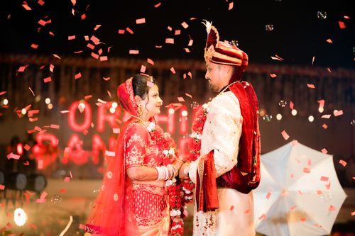 Free A joyful Indian couple in traditional attire during a vibrant nighttime wedding celebration. Stock Photo