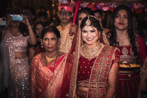 A bride in traditional indian attire poses for a photo