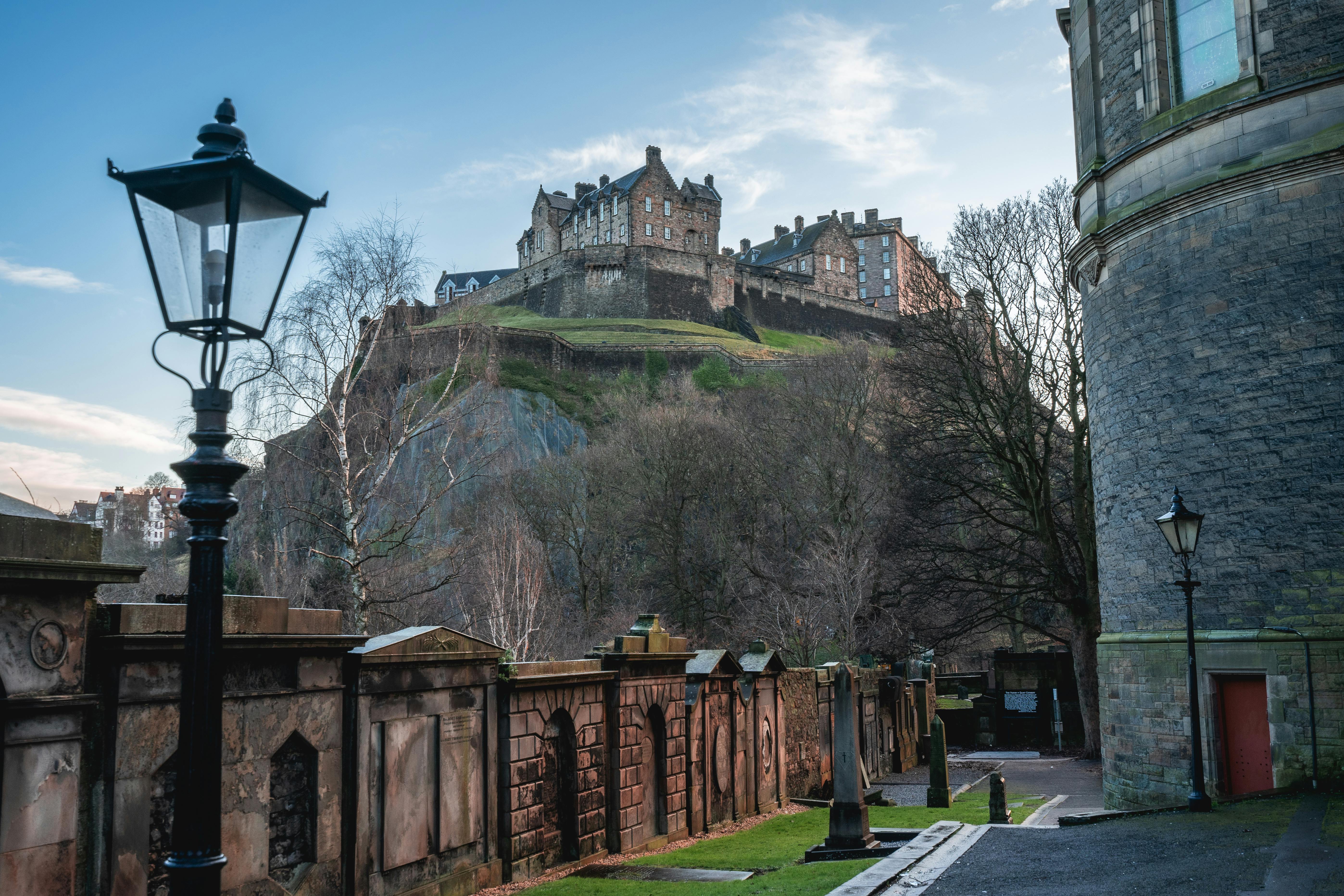 A captivating view of Edinburgh Castle from a nearby street in spring, featuring historic architecture.