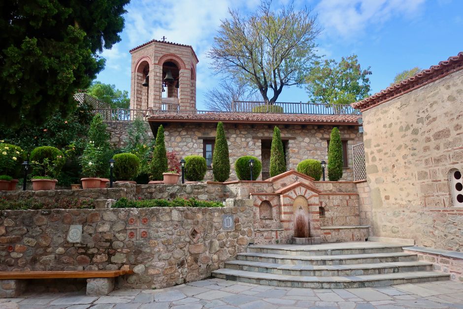 Peaceful courtyard of a historic monastery in Meteora, Greece, showcasing stone architecture.