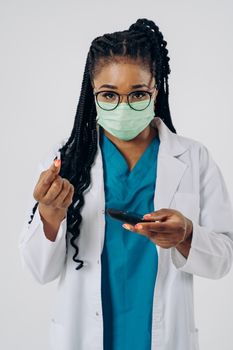 A healthcare professional wearing a mask measures glucose levels with precision.