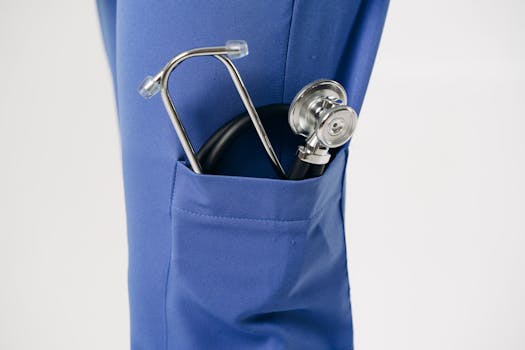 Closeup of a stethoscope in a blue pocket, representing healthcare professionalism.