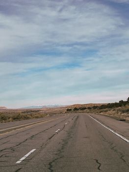 Vast open road through Arizona desert under a clear blue sky, ideal for travel and adventure themes.