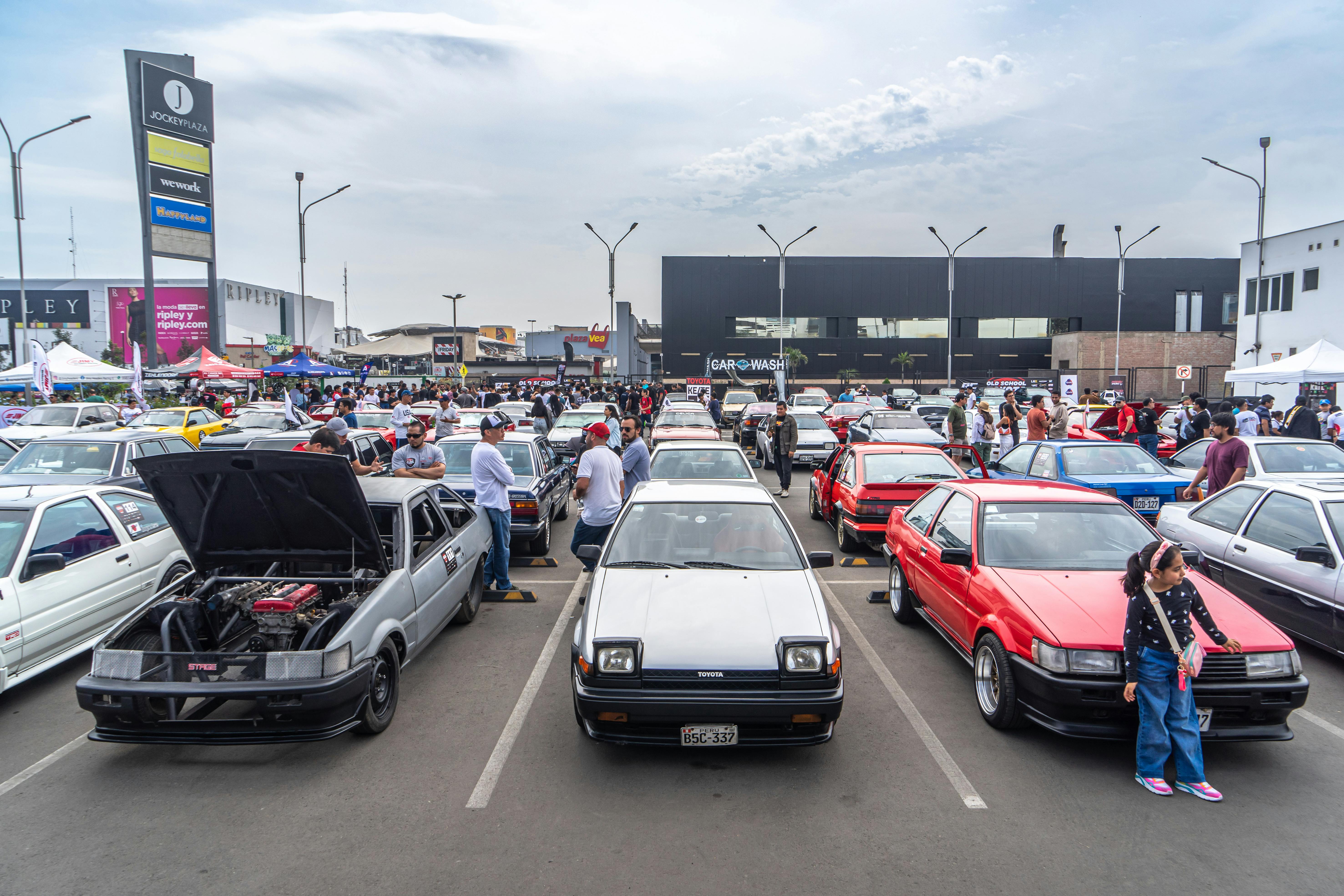 People Among Classic Japanese Cars at a Car Show