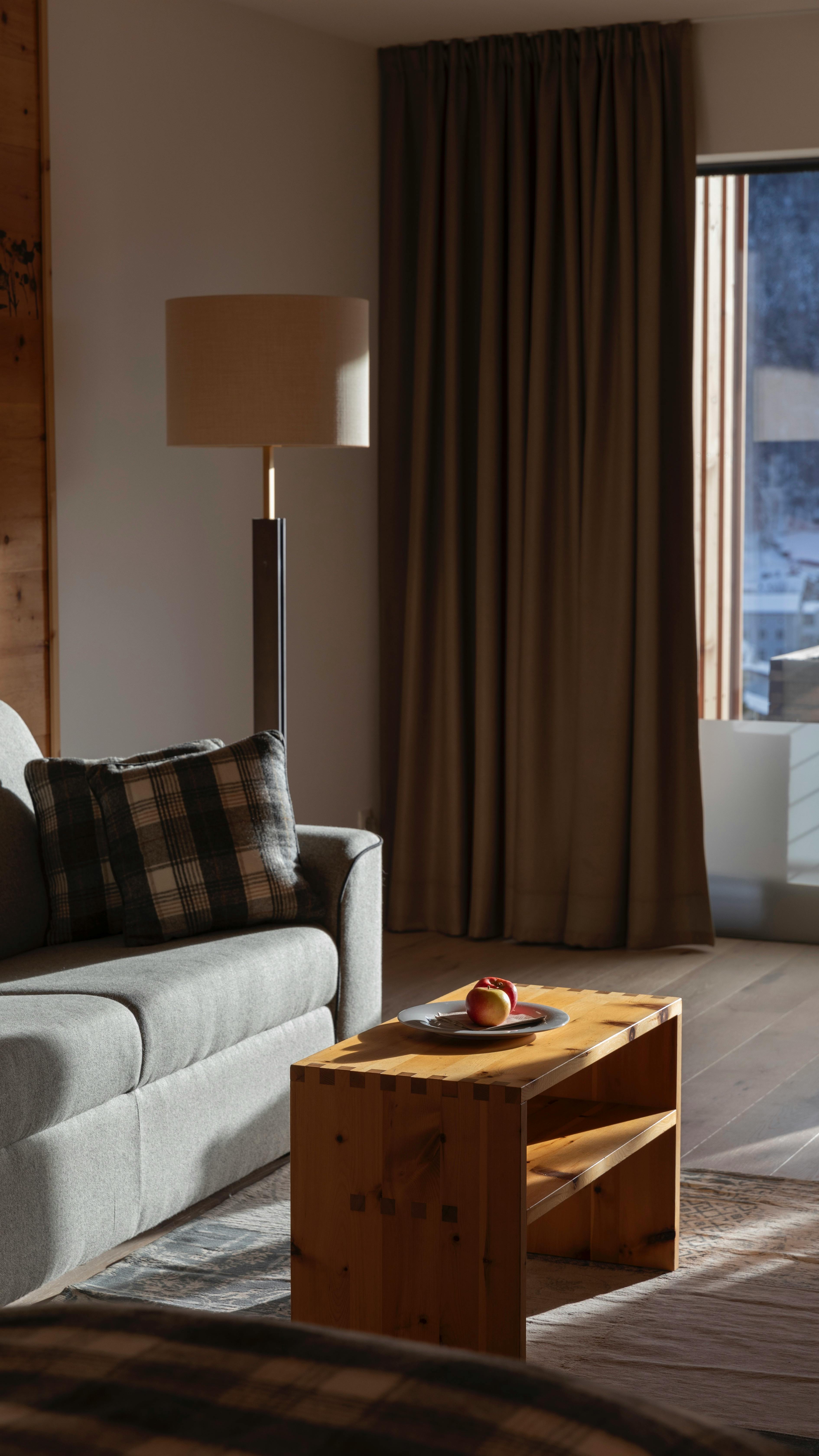 Elegant living room featuring a stylish sofa, lamp, and coffee table bathed in natural light.