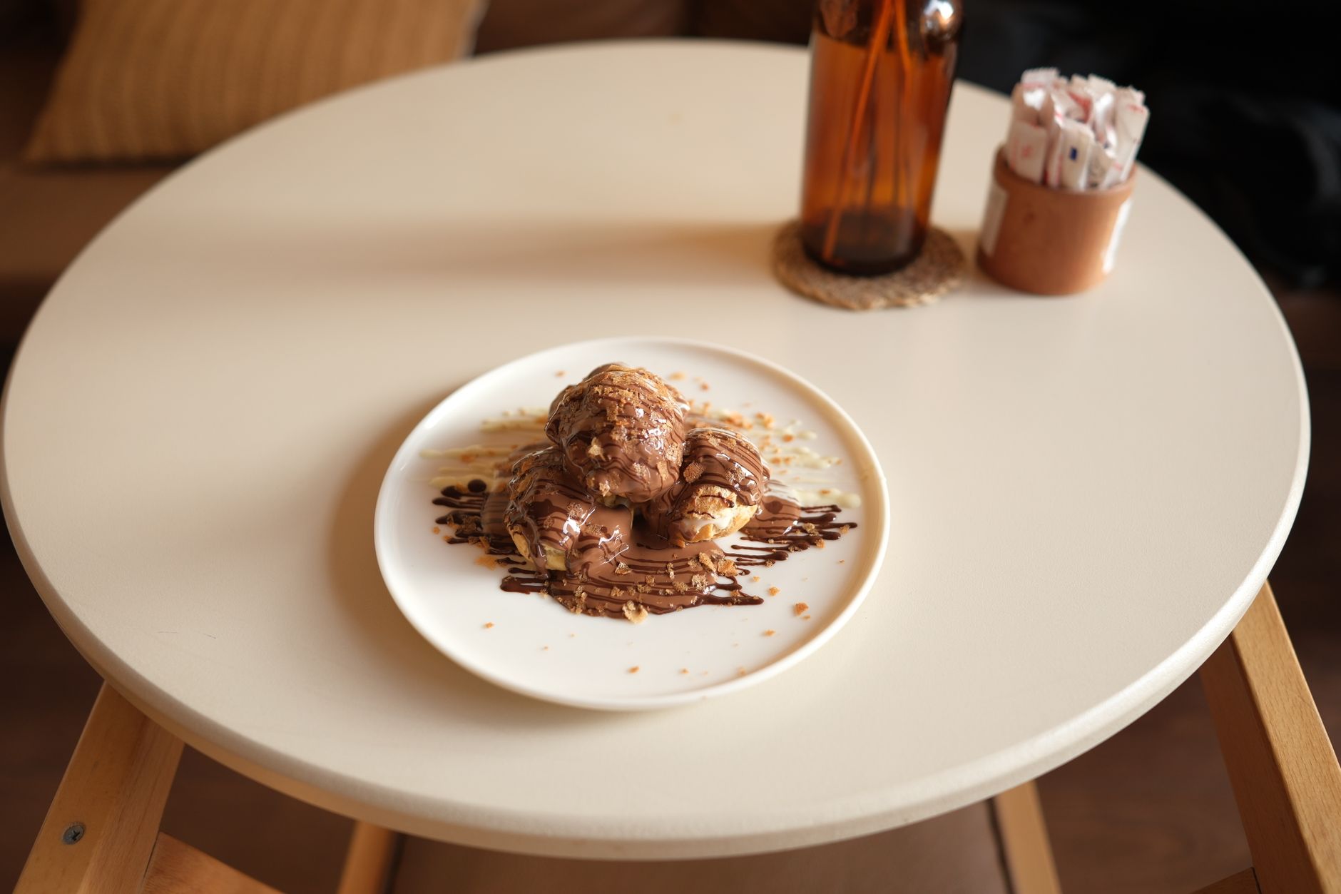 Golden cream puff on a plate with dusted sugar