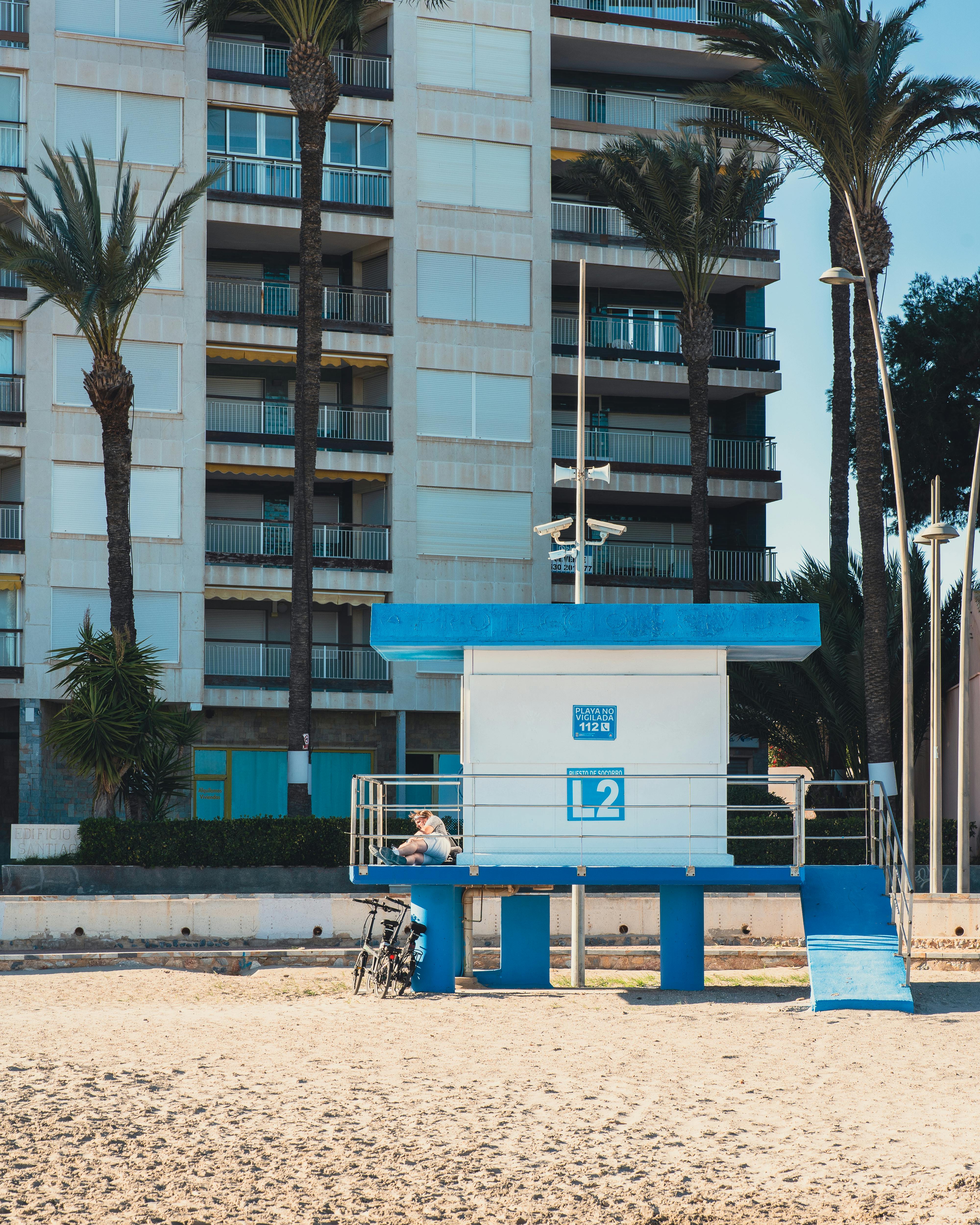 a lifeguard stand on the beach with palm trees