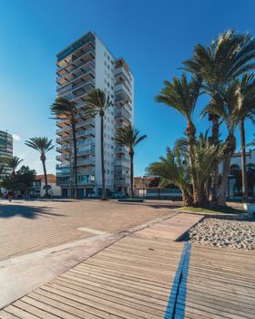 High-rise apartment with palm trees in sunny Santiago de la Ribera, Spain.