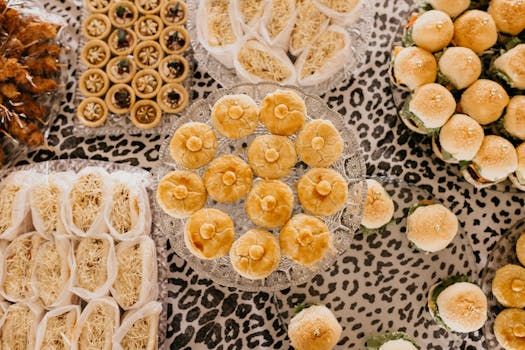 A variety of fresh pastries, tarts, and sandwiches beautifully arranged on a decorative table.