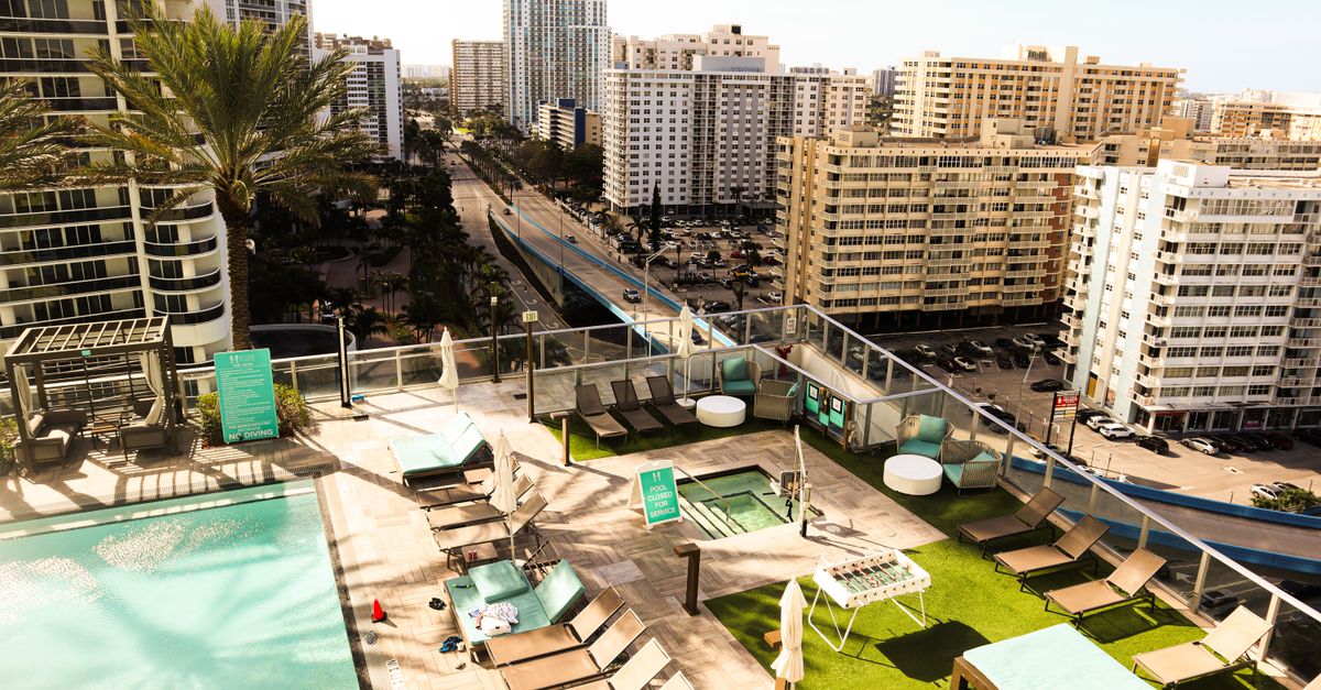 Aerial view of a luxurious rooftop pool area overlooking the vibrant downtown cityscape in Florida, USA.