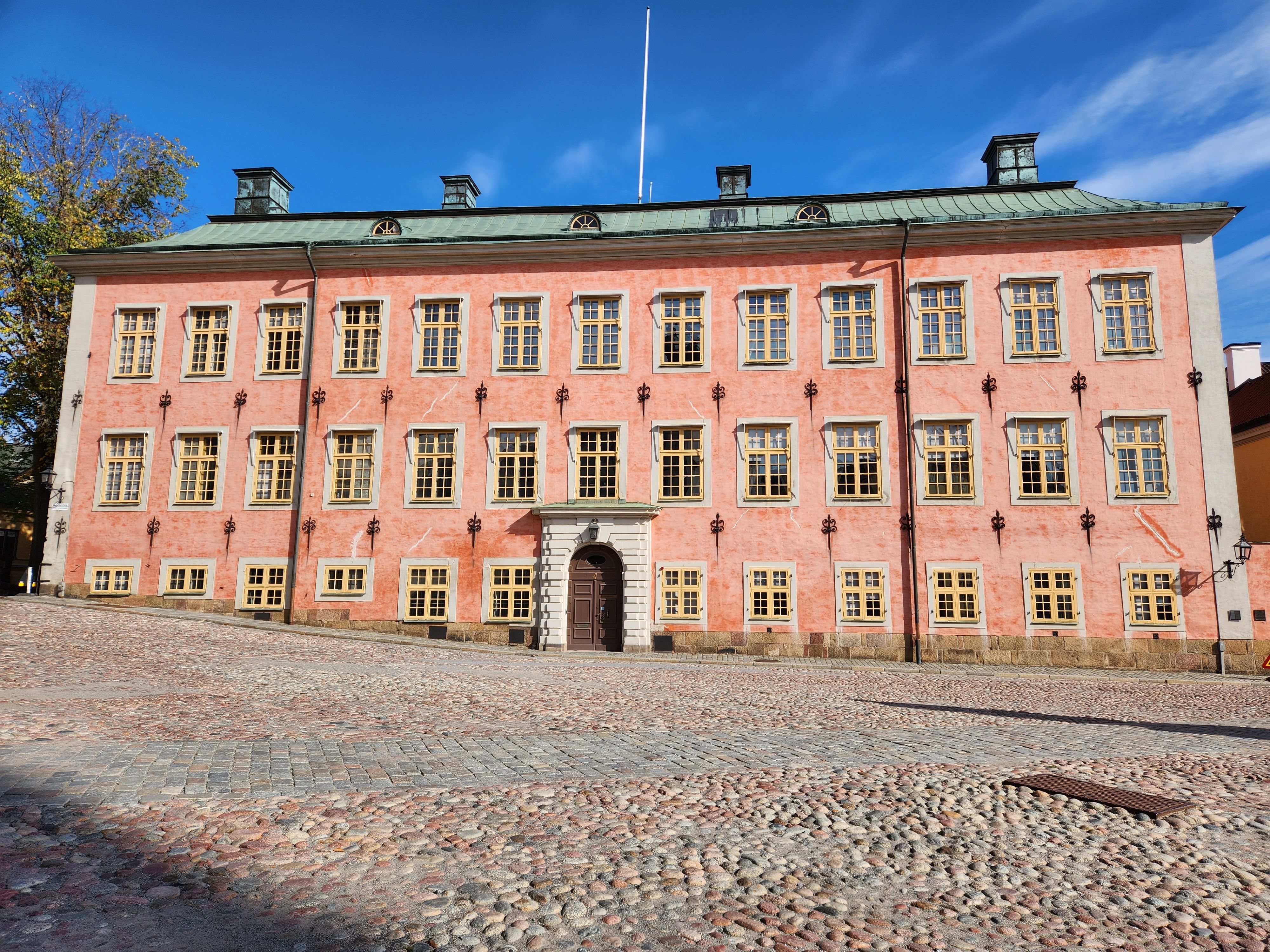 Stenbock Palace in Gamla Stan, Stockholm, featuring its distinctive pink facade and cobblestone courtyard.