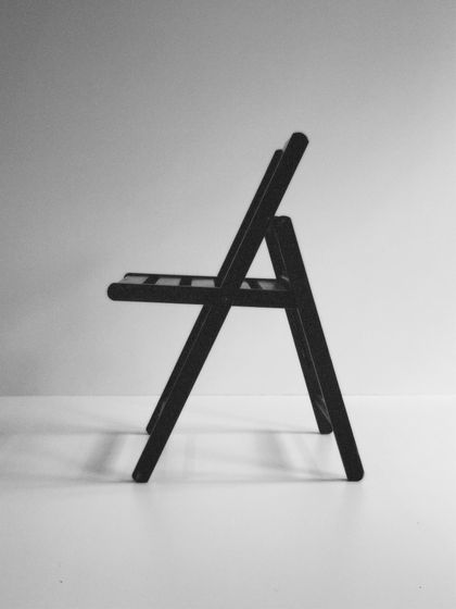 Black folding chair in profile, black and white — photo by Caio Mantovani on Pexels